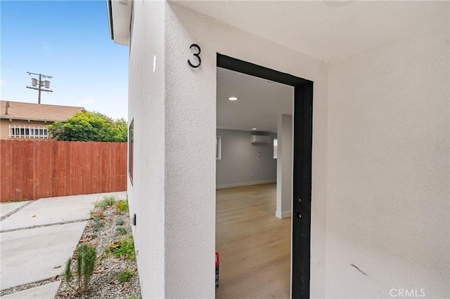 property entrance featuring fence and stucco siding