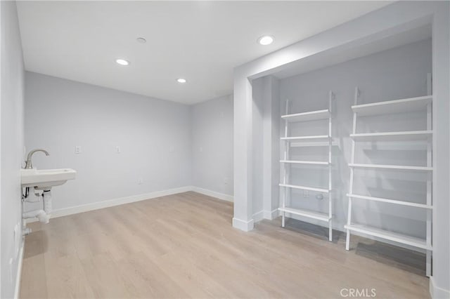 basement featuring recessed lighting, baseboards, and wood finished floors