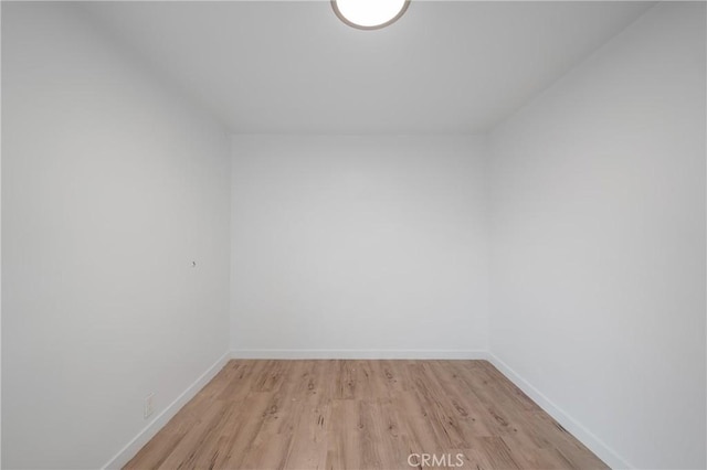 empty room featuring light wood-style flooring and baseboards