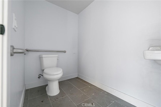 bathroom with toilet, tile patterned flooring, and baseboards