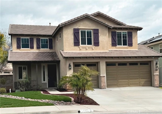 view of front of property with an attached garage, covered porch, concrete driveway, stucco siding, and a front yard