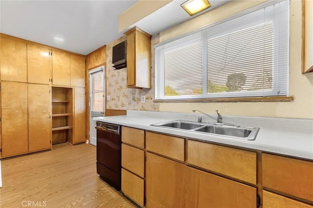 kitchen with dishwasher, light countertops, a sink, and light wood finished floors