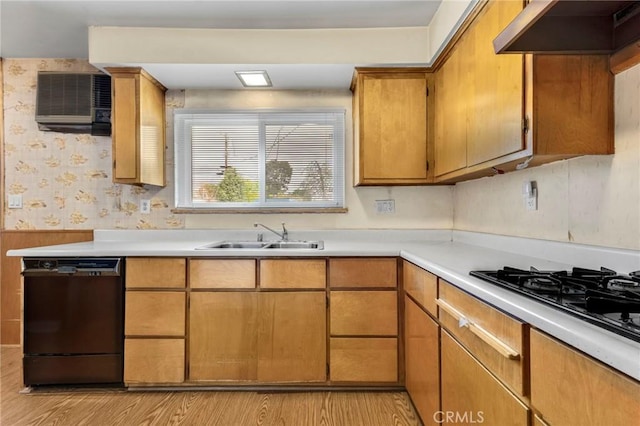 kitchen with light countertops, a sink, under cabinet range hood, black appliances, and wallpapered walls