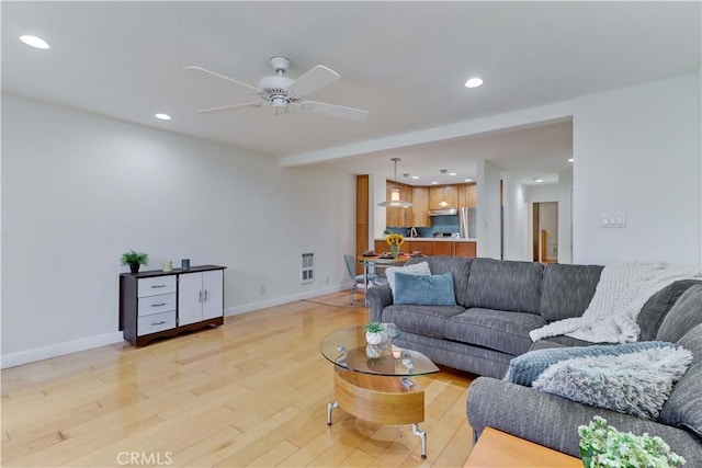 living area with light wood-style floors, baseboards, and recessed lighting