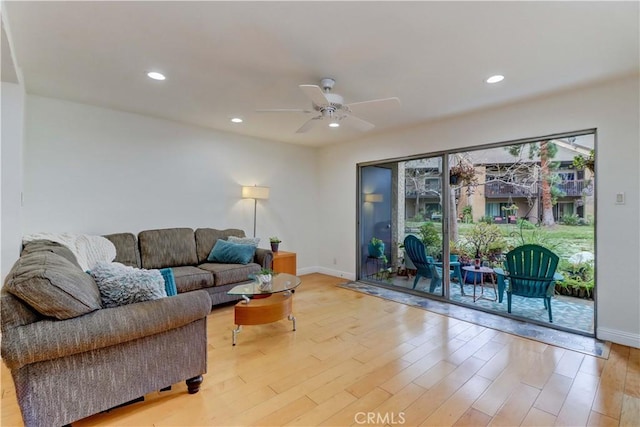 living room featuring ceiling fan, light wood-type flooring, baseboards, and recessed lighting