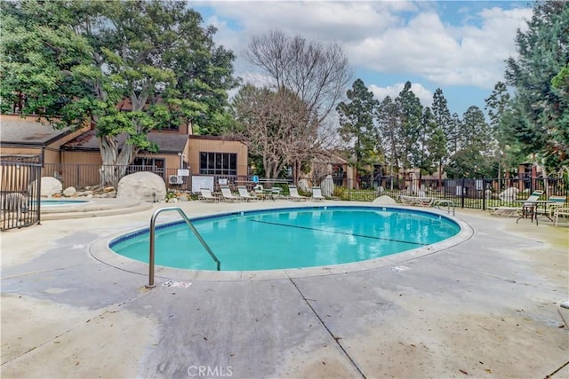 pool with fence and a patio