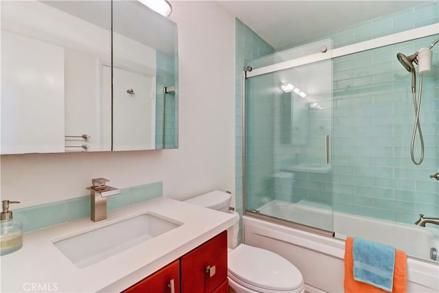 bathroom with vanity, toilet, and bath / shower combo with glass door