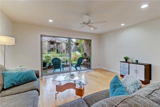 living room with baseboards, a ceiling fan, light wood-style flooring, and recessed lighting