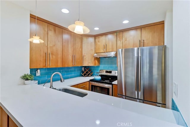 kitchen featuring tasteful backsplash, light countertops, appliances with stainless steel finishes, a sink, and under cabinet range hood