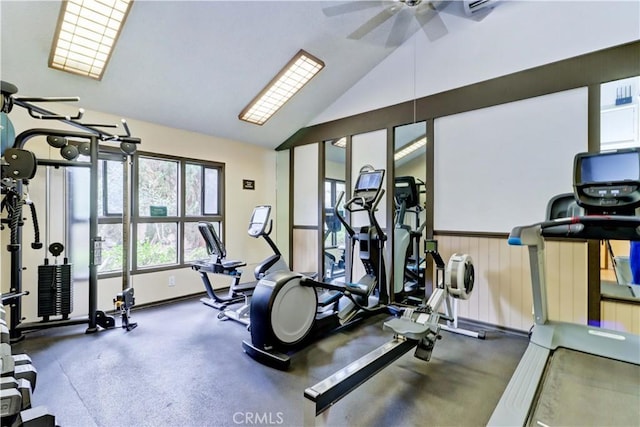 workout area featuring a wainscoted wall, vaulted ceiling, and a ceiling fan