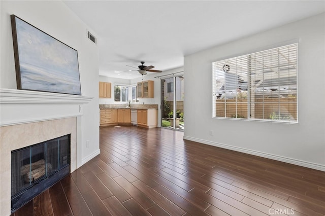 27139 Saddlepeak Trl, Valencia, CA 91354 - unfurnished living room with ceiling fan, dark wood finished floors, a glass covered fireplace, visible vents, and baseboards