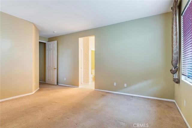 carpeted empty room featuring baseboards