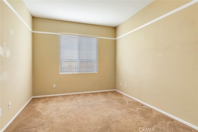 carpeted spare room featuring baseboards