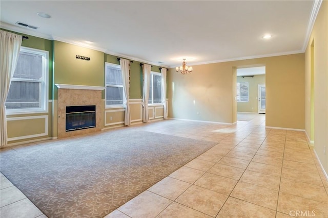 unfurnished living room with light tile patterned floors, visible vents, a glass covered fireplace, ornamental molding, and a notable chandelier