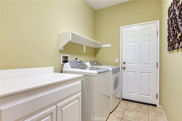 clothes washing area featuring light tile patterned floors, independent washer and dryer, and cabinet space