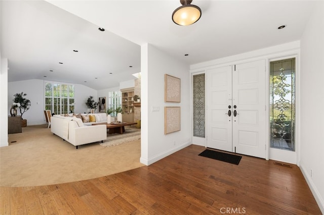 entryway featuring baseboards, lofted ceiling, and wood-type flooring