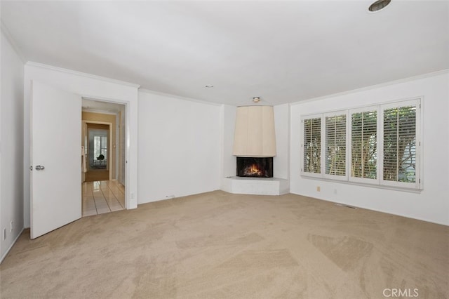 unfurnished living room featuring a multi sided fireplace, light colored carpet, and crown molding