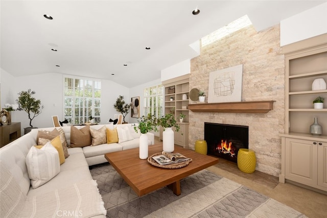 living area with built in features, lofted ceiling, and a stone fireplace