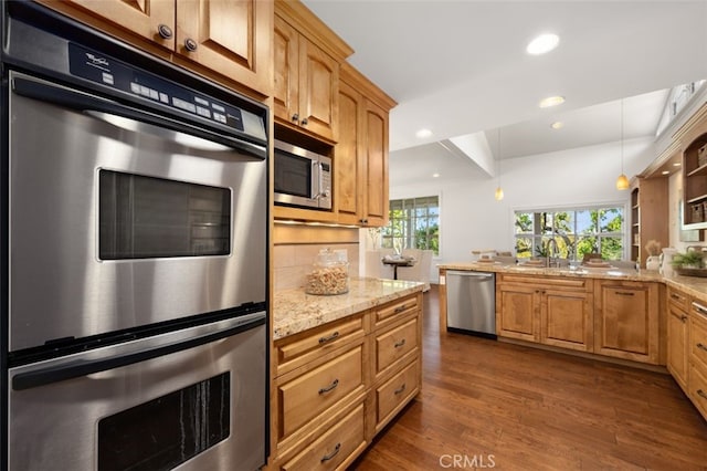 kitchen featuring dark wood-type flooring, light stone countertops, recessed lighting, appliances with stainless steel finishes, and a sink