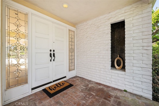 view of exterior entry with brick siding