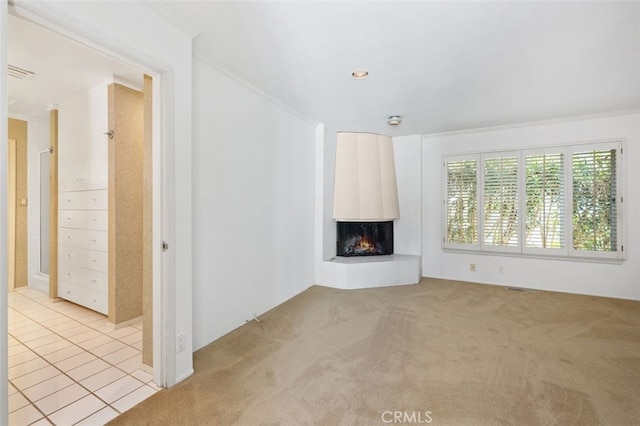 unfurnished living room with carpet flooring, visible vents, and a large fireplace