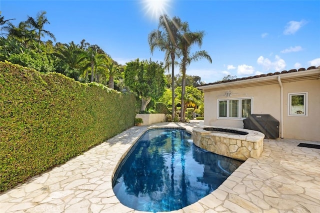 view of pool featuring grilling area, an in ground hot tub, and fence