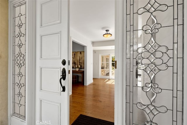 entryway with baseboards and wood finished floors