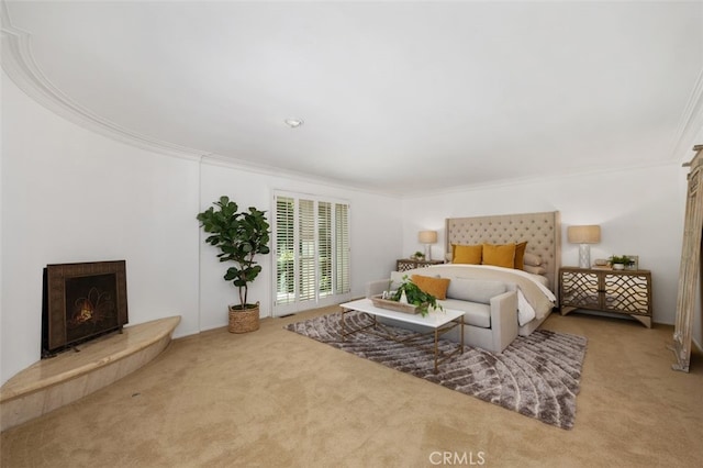 carpeted bedroom featuring a warm lit fireplace and ornamental molding