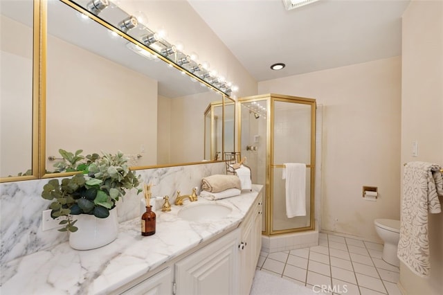 bathroom featuring tile patterned flooring, a shower stall, toilet, and vanity