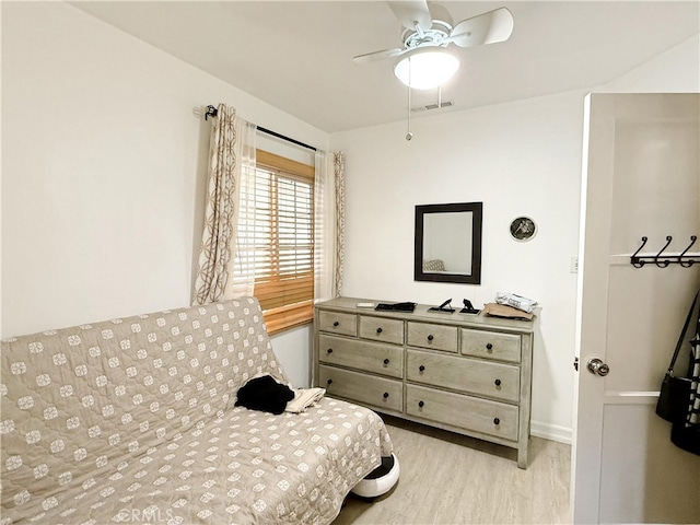 bedroom with light wood-type flooring, baseboards, visible vents, and a ceiling fan