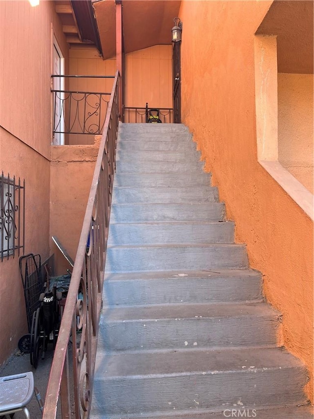 stairs featuring a high ceiling and a textured wall