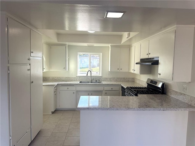 kitchen featuring a peninsula, under cabinet range hood, stainless steel range with gas cooktop, a sink, and light tile patterned flooring