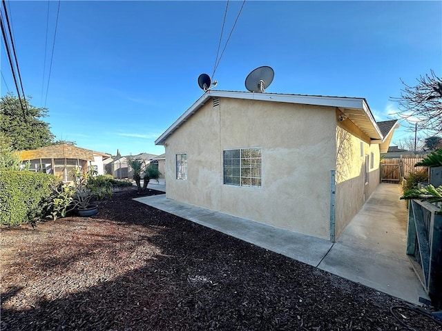 view of property exterior with fence and stucco siding