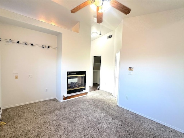 unfurnished living room featuring lofted ceiling, carpet floors, a multi sided fireplace, visible vents, and a ceiling fan