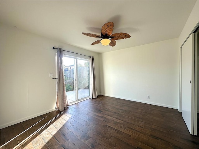 unfurnished room with a ceiling fan, dark wood-style flooring, and baseboards