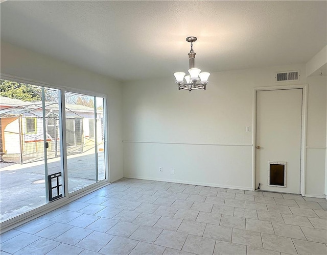 empty room with visible vents, a notable chandelier, a textured ceiling, and baseboards