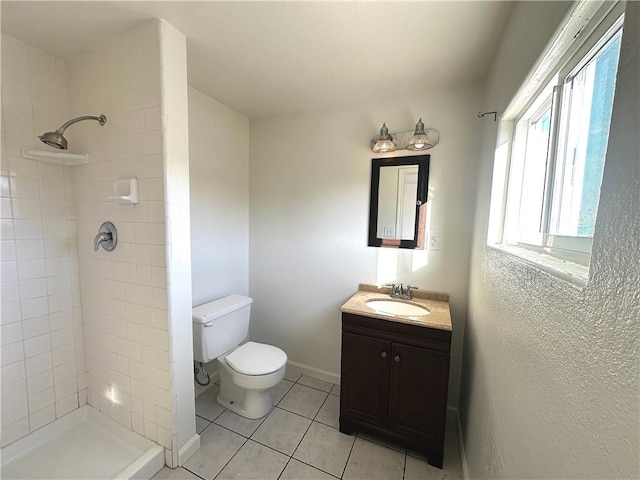 full bathroom with tile patterned flooring, a tile shower, vanity, and toilet