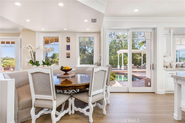 dining space featuring light wood-style floors, recessed lighting, visible vents, and ornamental molding