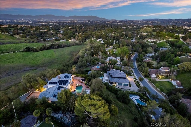 aerial view at dusk featuring a mountain view