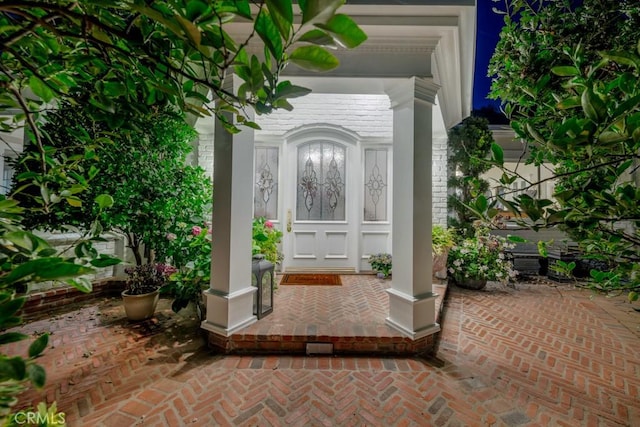 view of exterior entry featuring brick siding