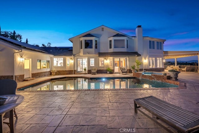 view of pool with a patio area and a pool with connected hot tub