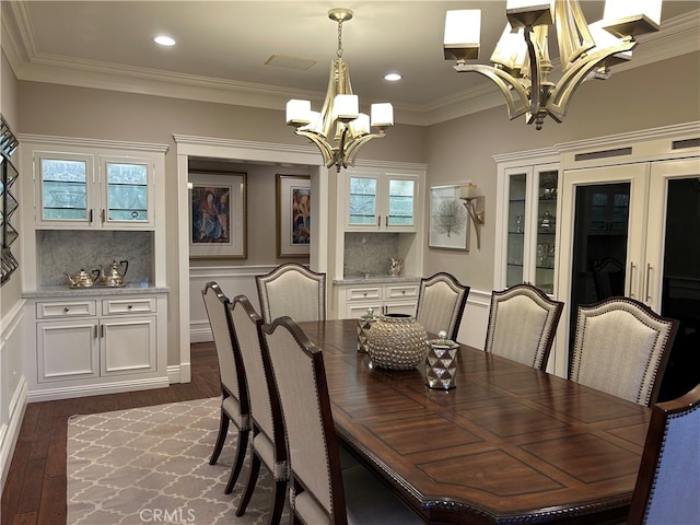 dining room with an inviting chandelier, recessed lighting, dark wood-style floors, and ornamental molding