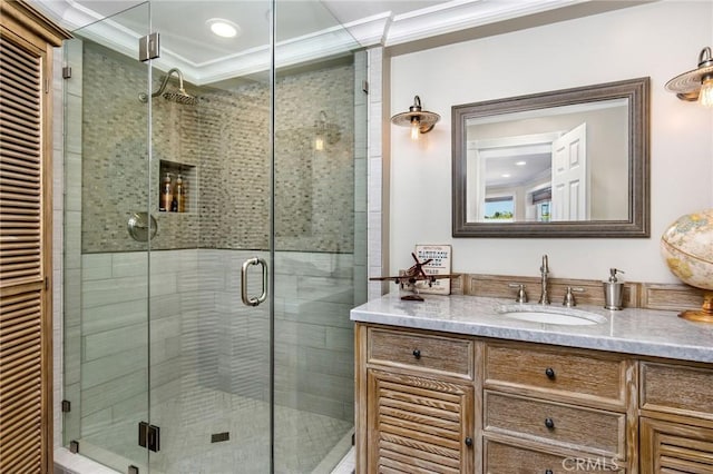 bathroom featuring ornamental molding, a shower stall, and vanity