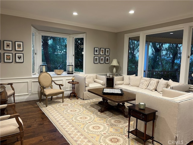 living area with wainscoting, dark wood finished floors, crown molding, and a decorative wall