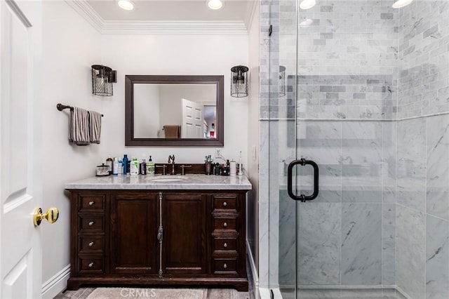 bathroom featuring a stall shower, crown molding, vanity, and baseboards