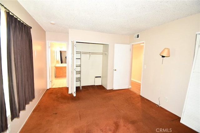 unfurnished bedroom featuring carpet floors, a closet, visible vents, and a textured ceiling