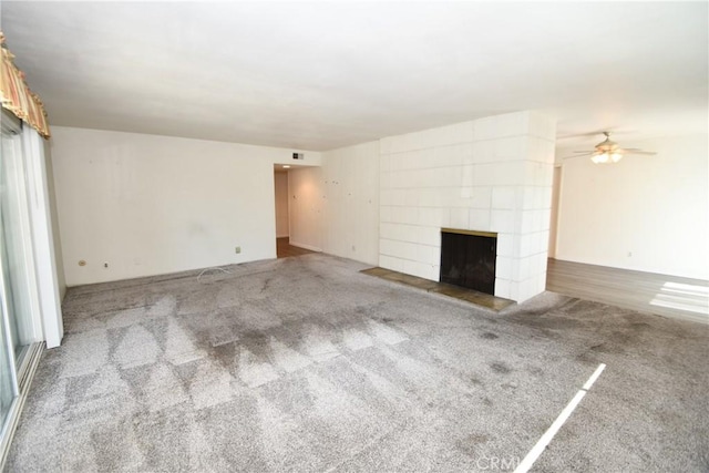 unfurnished living room featuring carpet floors and a tile fireplace