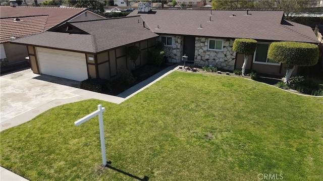 ranch-style home featuring a garage, stone siding, driveway, and a front lawn