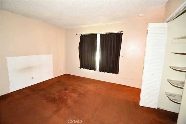 carpeted spare room featuring a textured ceiling