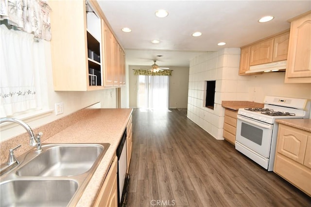 kitchen featuring dark wood-style flooring, white gas range, light brown cabinetry, under cabinet range hood, and a sink